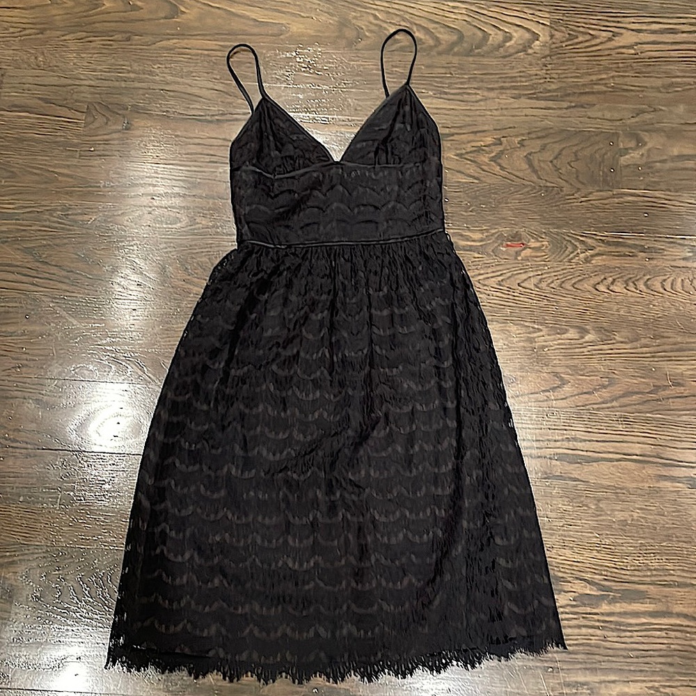 Black lace cocktail dress with adjustable straps.